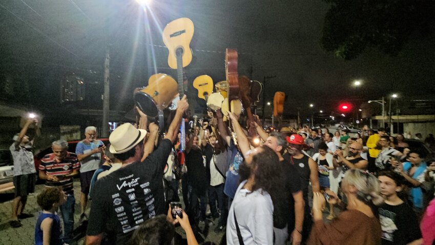 Palco iluminado em apresentação de seresta com público ao fundo